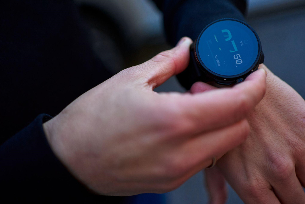 Manos ajustando un reloj Suunto Race en un ultramaratón